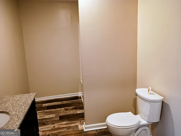 a bathroom with a granite countertop toilet and a sink