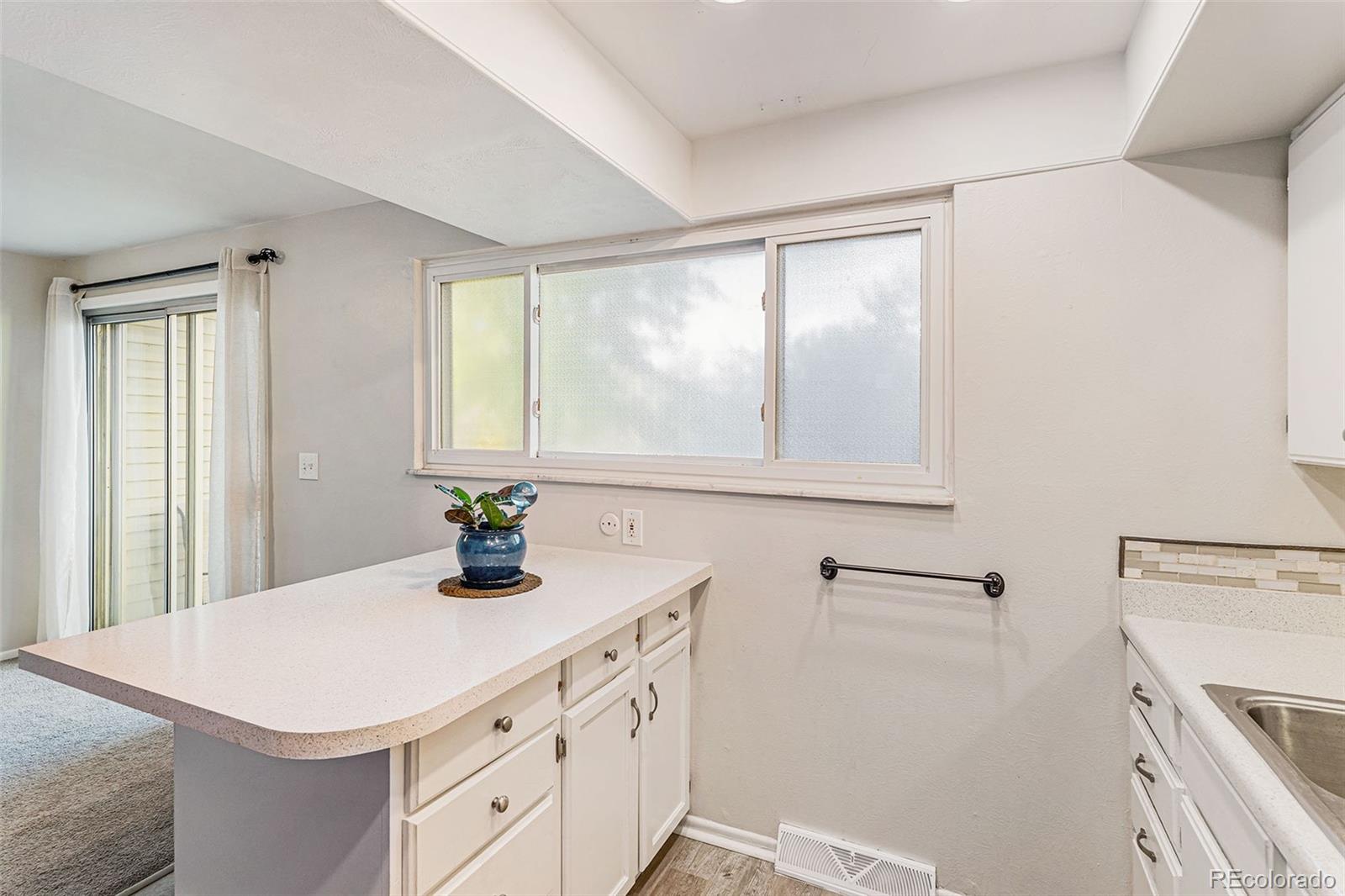 4262 East Maplewood Way Centennial, CO 80121 - Photo 13 of 32 a kitchen with a stove a sink and a window