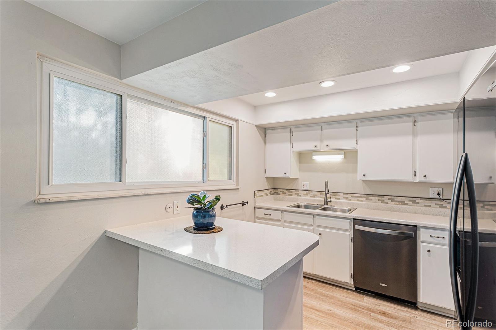 4262 East Maplewood Way Centennial, CO 80121 - Photo 3 of 32 a kitchen with stainless steel appliances cabinets a sink and a window