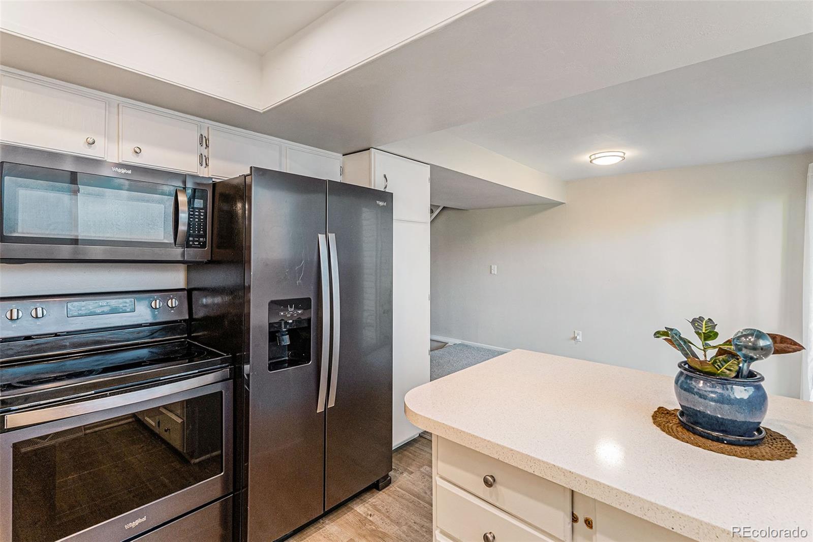 4262 East Maplewood Way Centennial, CO 80121 - Photo 4 of 32 a kitchen with a refrigerator and microwave