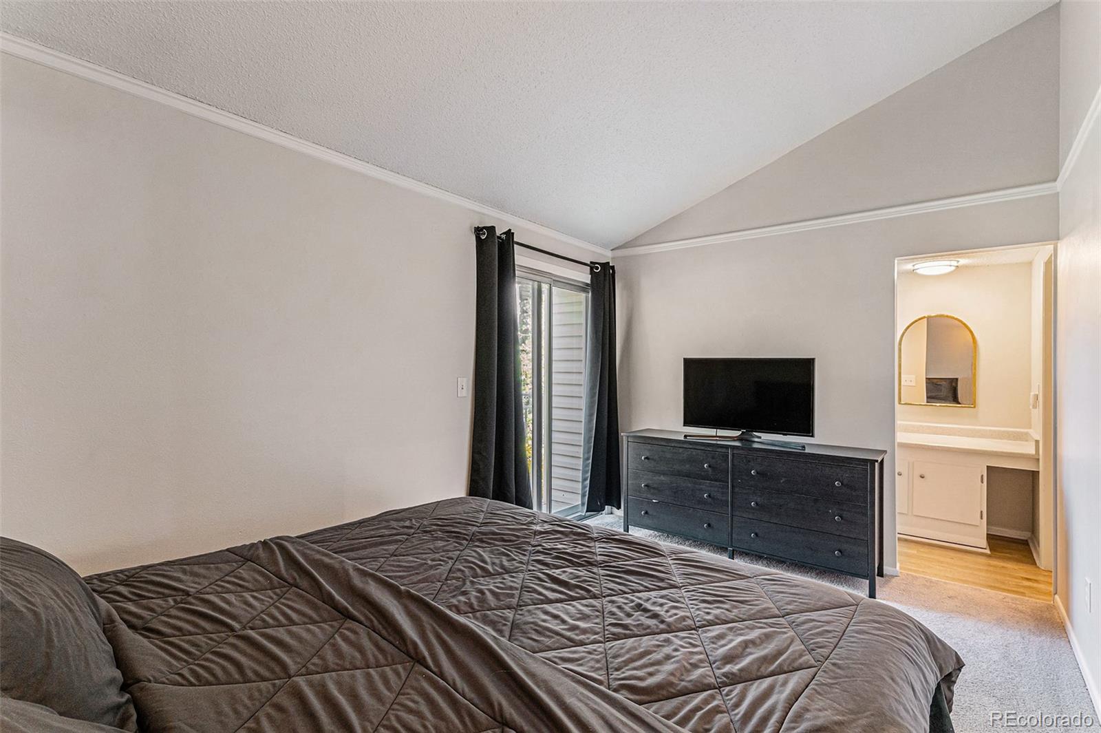 4262 East Maplewood Way Centennial, CO 80121 - Photo 9 of 32 a bedroom with a bed and a flat screen tv