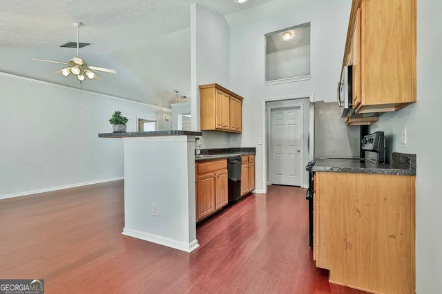 a kitchen with stainless steel appliances cabinets a wooden floor and a sink