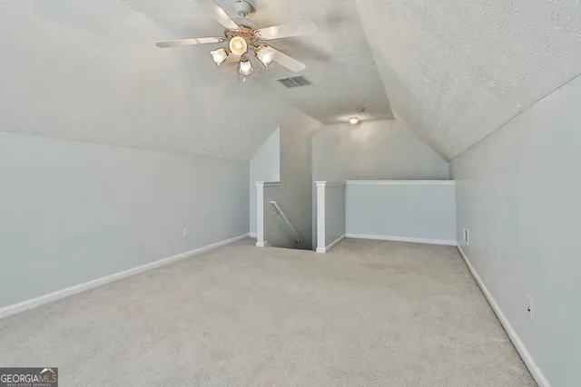 en empty room with windows and ceiling fan