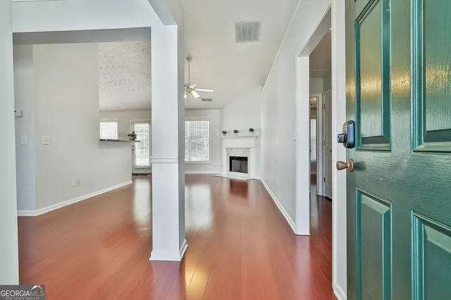 a view of a hallway with wooden floor fireplace and living room