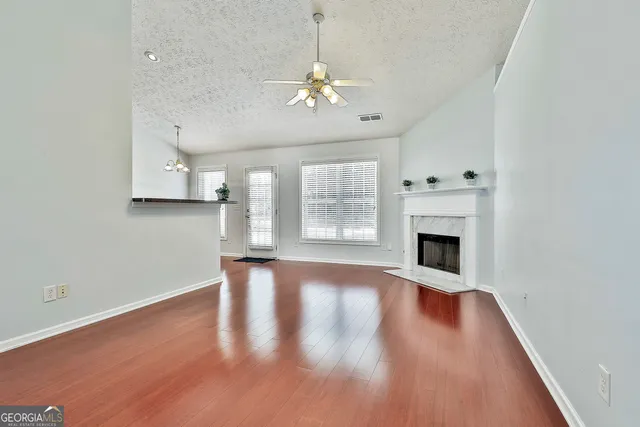 a view of empty room with wooden floor and fireplace