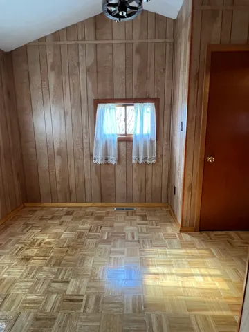 a view of a room with wooden floor and windows