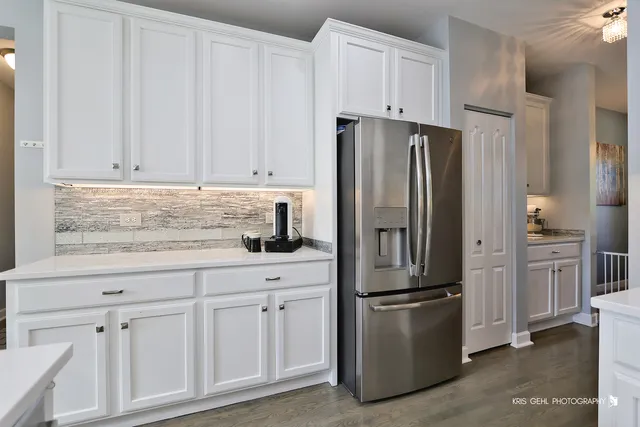 a kitchen with stainless steel appliances granite countertop a refrigerator stove and white cabinets