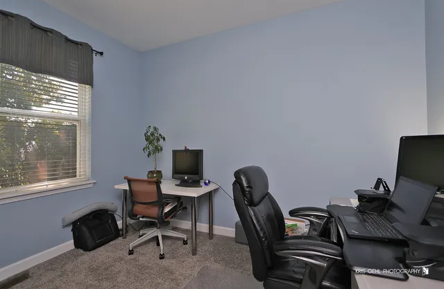 a view of a workspace with furniture and a window