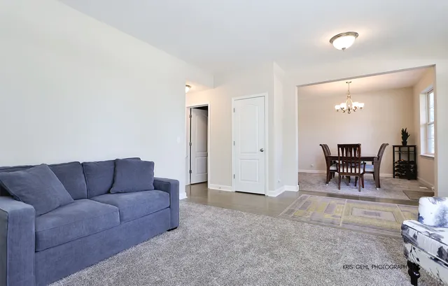 a living room with furniture and a dining table with rug