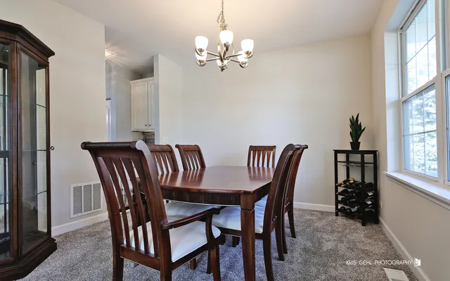 a view of a dining room with furniture and chandelier