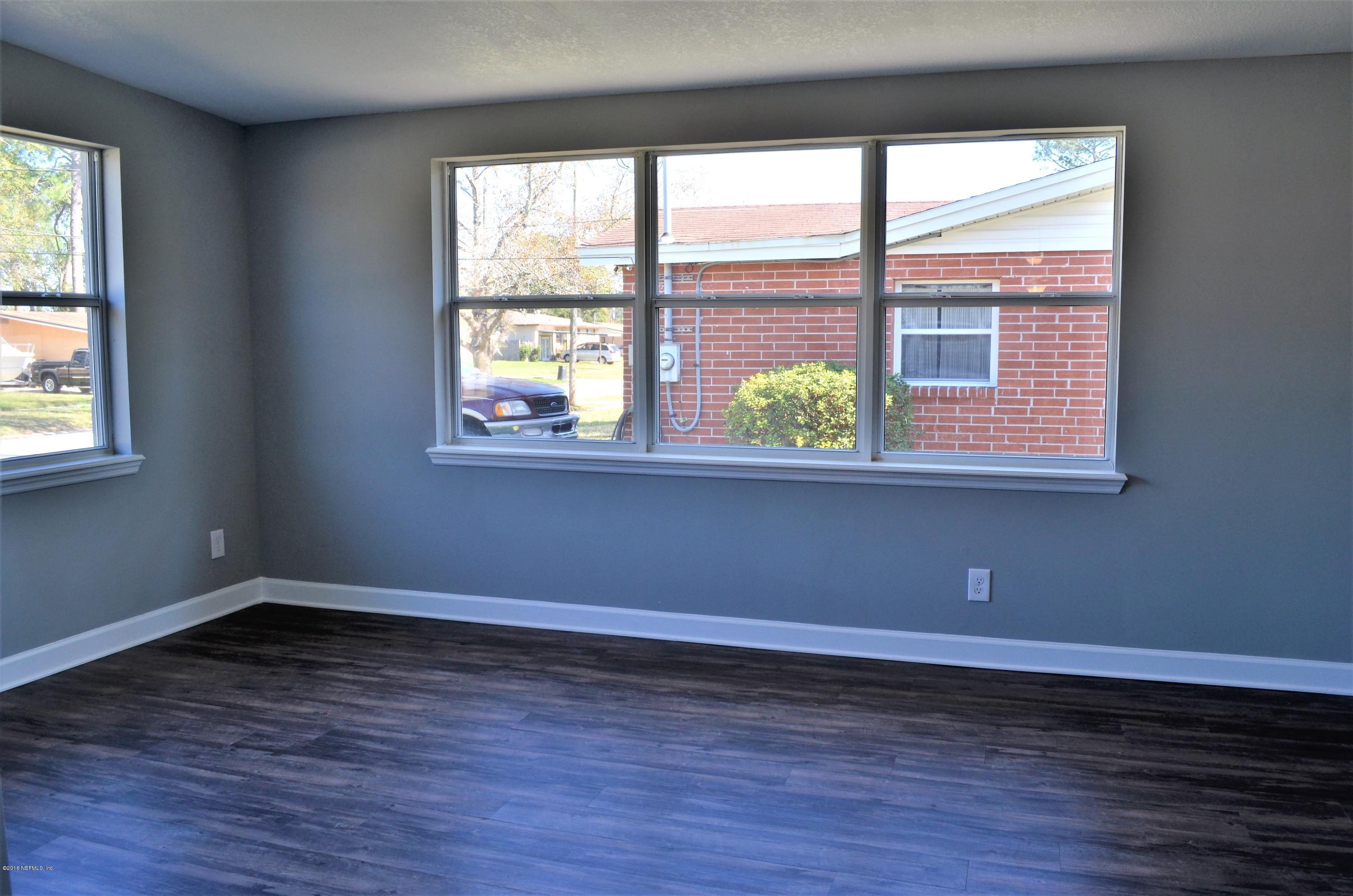 5520 Sabena Road Jacksonville, FL 32207 - Photo 5 of 8 a view of an empty room with wooden floor and a window