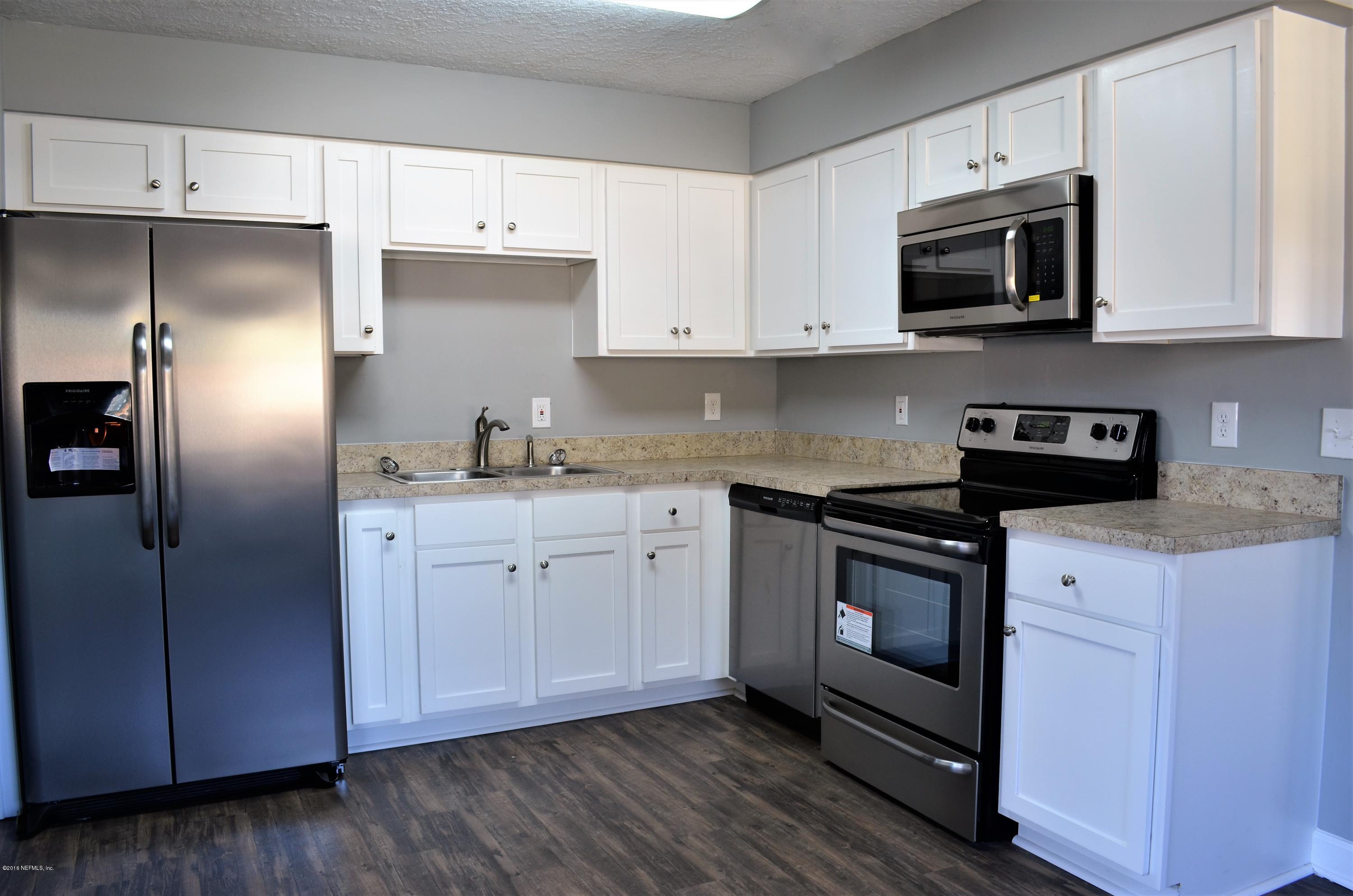 5520 Sabena Road Jacksonville, FL 32207 - Photo 6 of 8 a kitchen with cabinets stainless steel appliances a sink and wooden floor