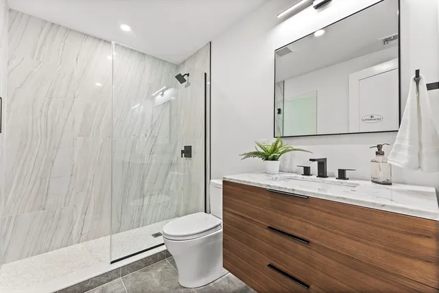 a bathroom with a double vanity sink toilet and shower