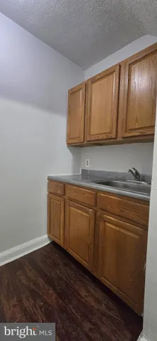 a kitchen with granite countertop cabinets and a wooden floor