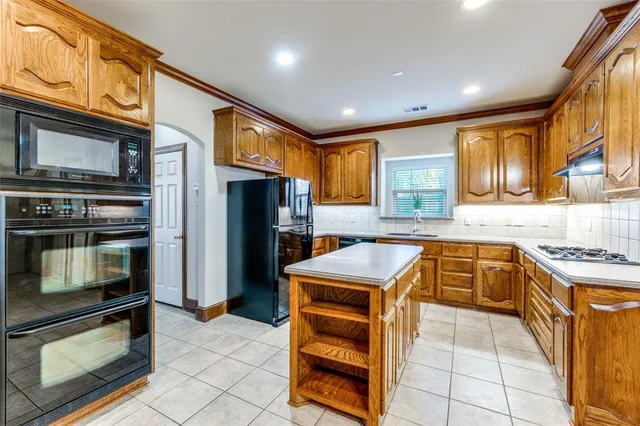 a kitchen with stainless steel appliances granite countertop a refrigerator and a stove top oven