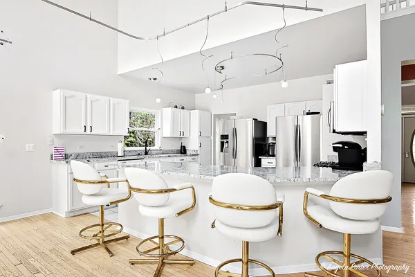 a kitchen with granite countertop a refrigerator oven a sink dishwasher and a refrigerator with wooden floor