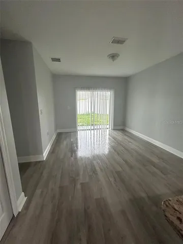 wooden floor in an empty room with a window