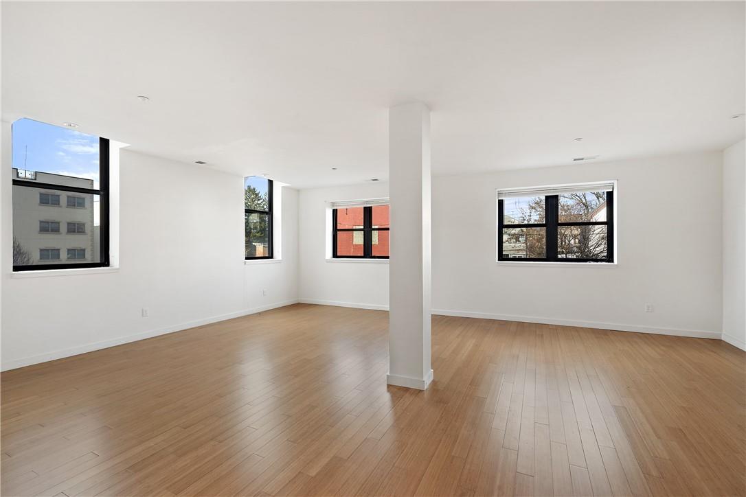 a view of a big room with wooden floor and windows