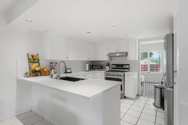 a kitchen with white cabinets and appliances