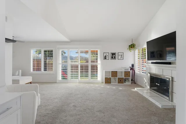 a living room with furniture a flat screen tv and a fireplace
