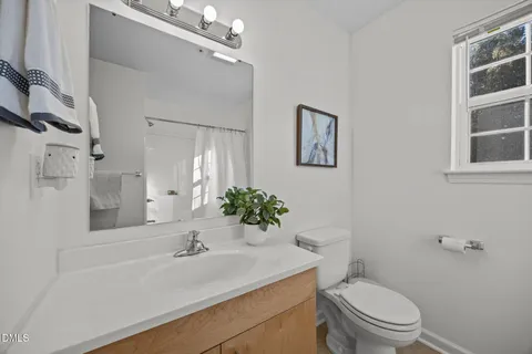 a bathroom with a sink vanity mirror and toilet