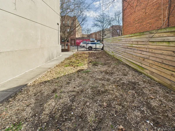 a view of a yard with wooden fence