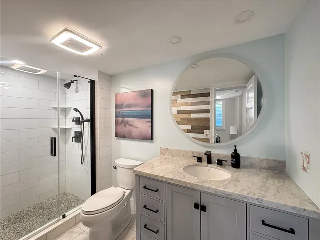 a bathroom with a granite countertop sink toilet and shower