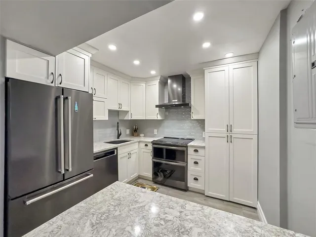 a kitchen with stainless steel appliances granite countertop a refrigerator and a stove top oven
