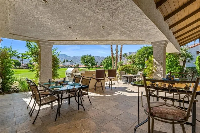 a view of a patio with table and chairs under an umbrella