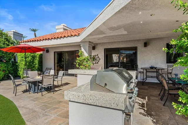 a view of a patio with table and chairs potted plants and a large tree