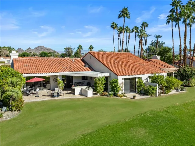 a front view of a house with a garden and yard