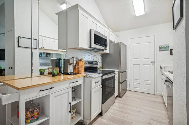 a kitchen with stainless steel appliances granite countertop a refrigerator and a stove top oven