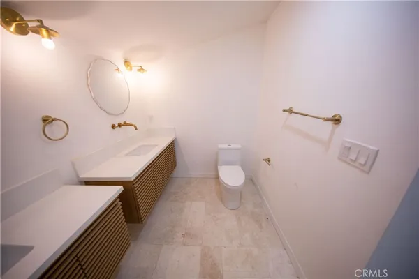 a spacious bathroom with a double vanity sink toilet and a mirror
