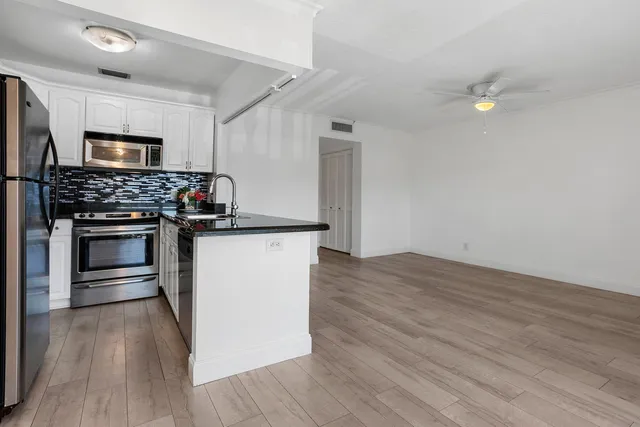 a kitchen with stainless steel appliances granite countertop a stove a refrigerator and a microwave