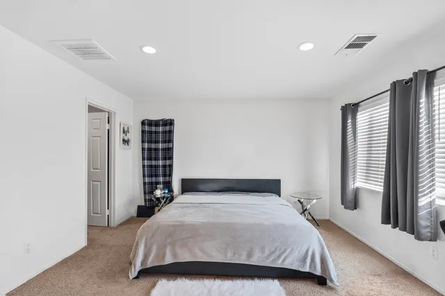 a bedroom with a bed and a large window
