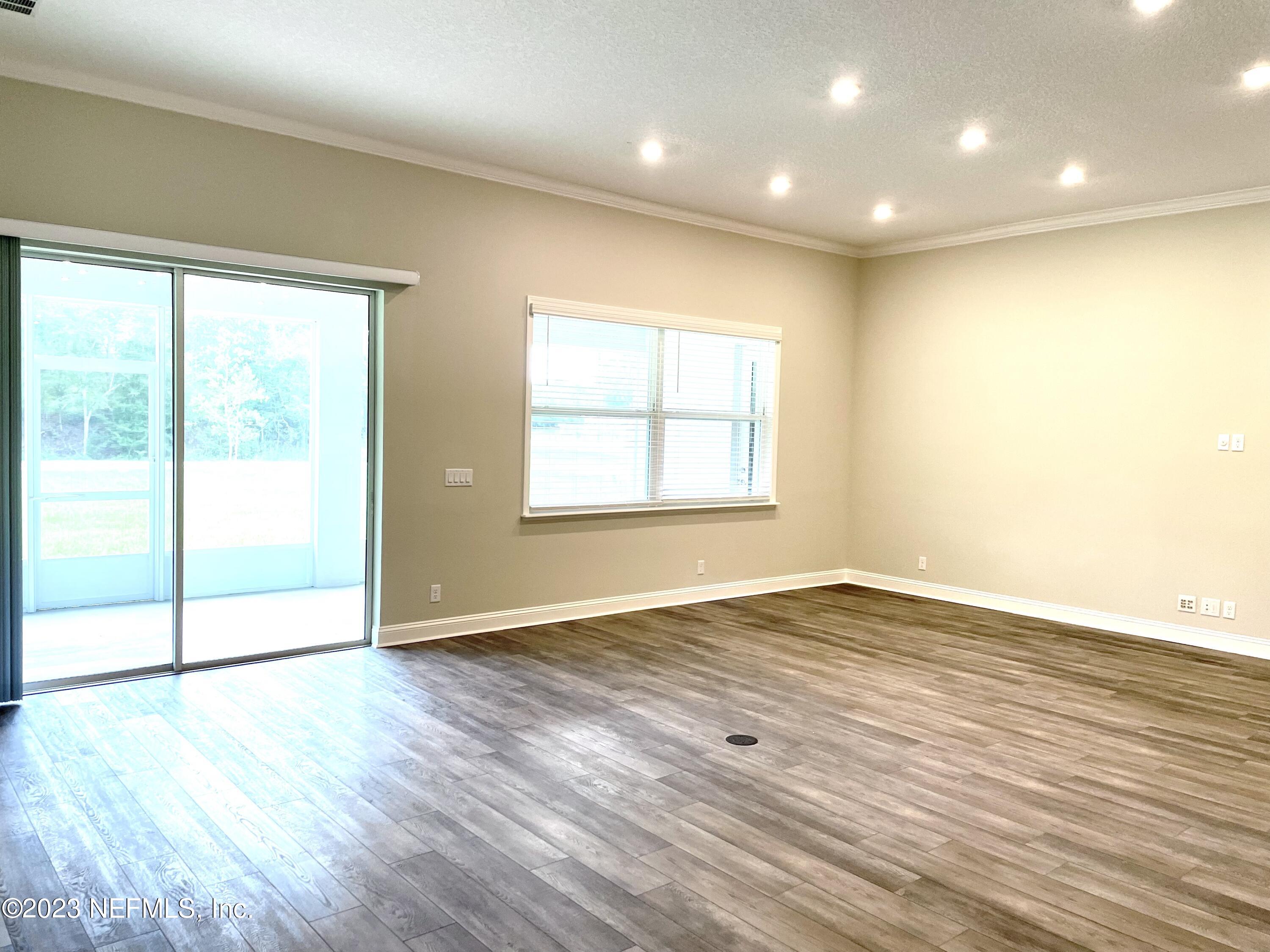 1521 Lake Foxmeadow Road Middleburg, FL 32068 - Photo 12 of 25 an empty room with wooden floor and windows