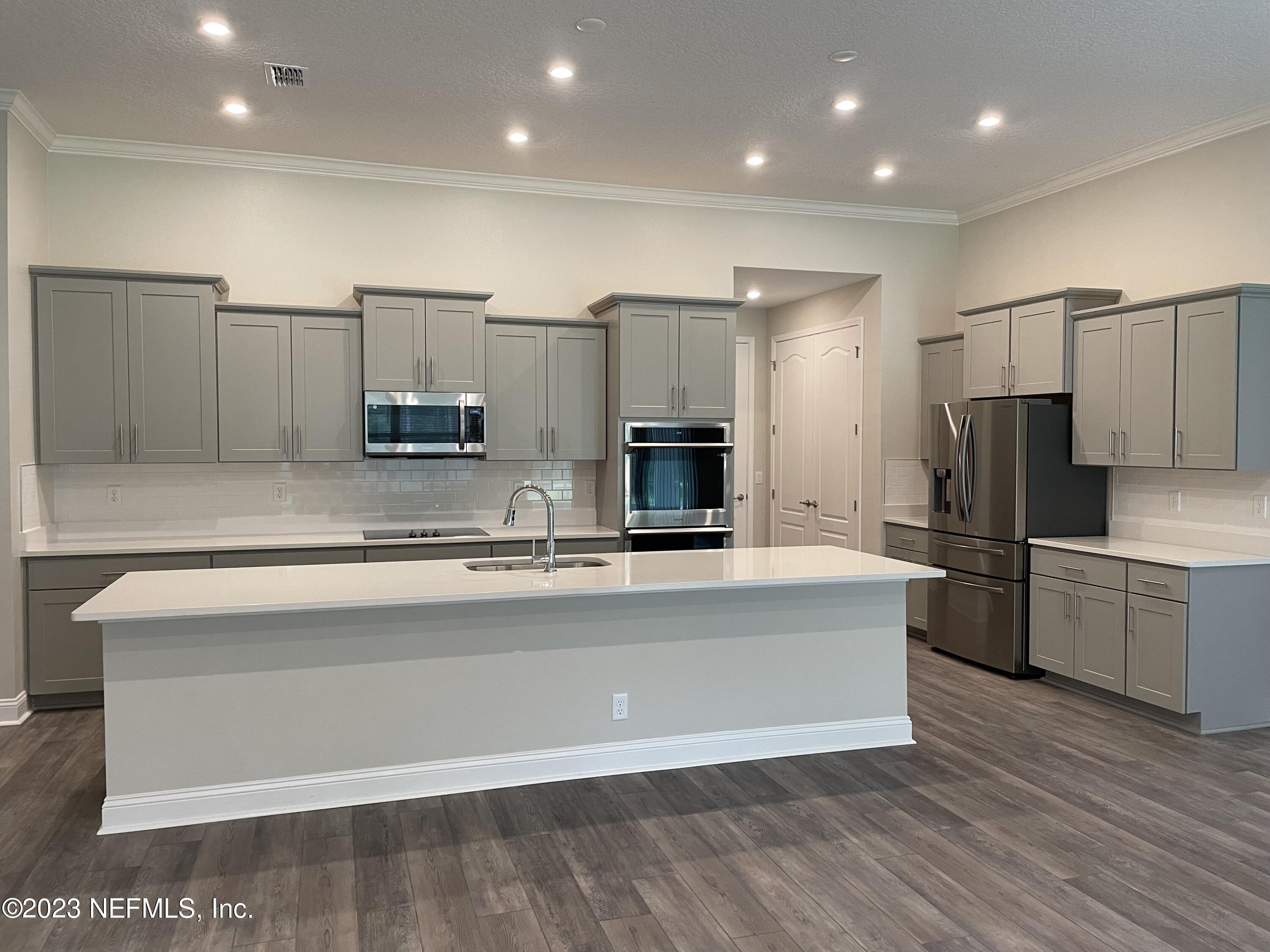 1521 Lake Foxmeadow Road Middleburg, FL 32068 - Photo 10 of 25 a large kitchen with stainless steel appliances a large counter top a stove a sink and a refrigerator