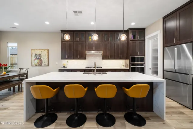 a kitchen with cabinets a sink and chairs