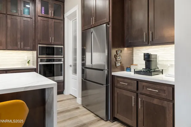a kitchen with granite countertop a refrigerator stove and sink