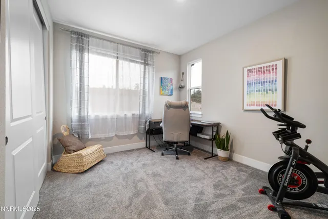 a view of a workspace with furniture and a window