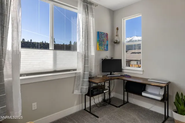 a view of a workspace with furniture and a window