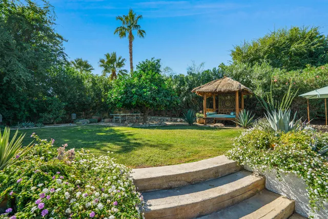a view of a house with backyard and sitting area