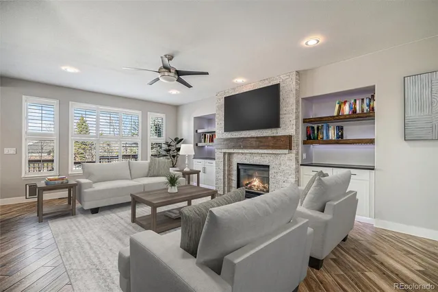 a living room with furniture a flat screen tv and a fireplace