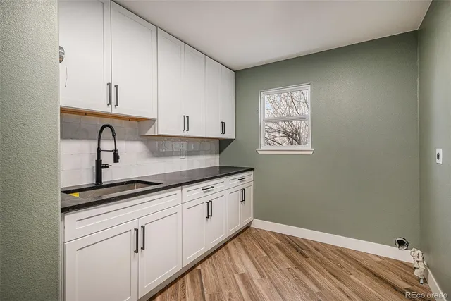 a kitchen with granite countertop white cabinets and sink