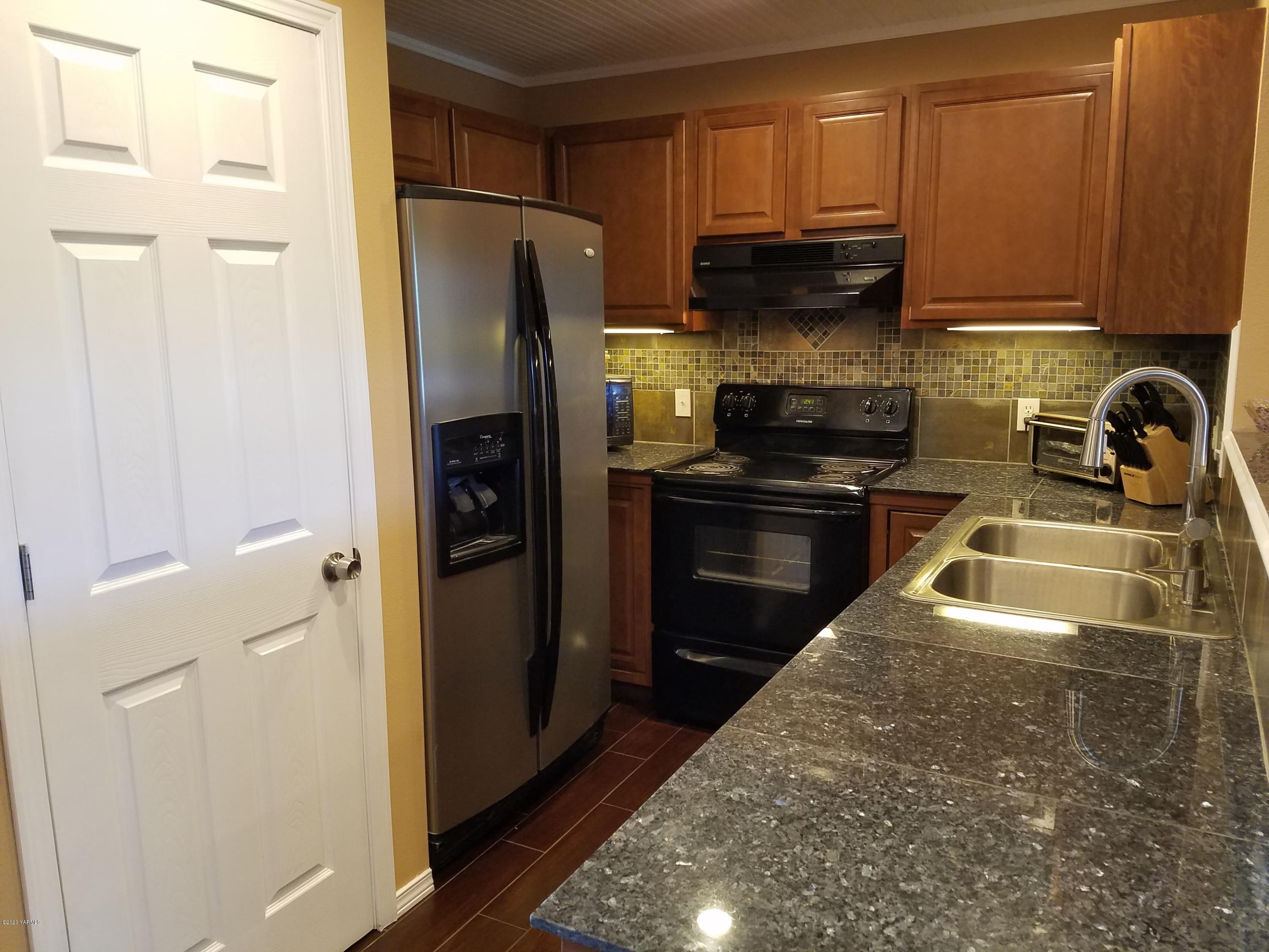 1920 South Euclid Road Grandview, WA 98930 - Photo 4 of 20 a kitchen with stainless steel appliances granite countertop a refrigerator a stove and a sink