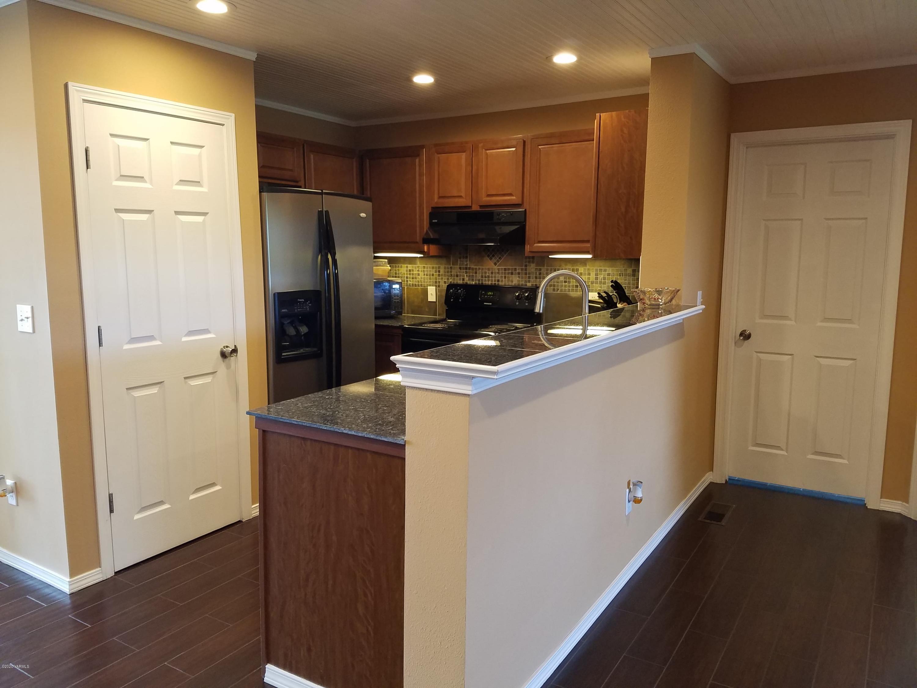 1920 South Euclid Road Grandview, WA 98930 - Photo 5 of 20 a kitchen with a refrigerator a stove top oven and wooden floor