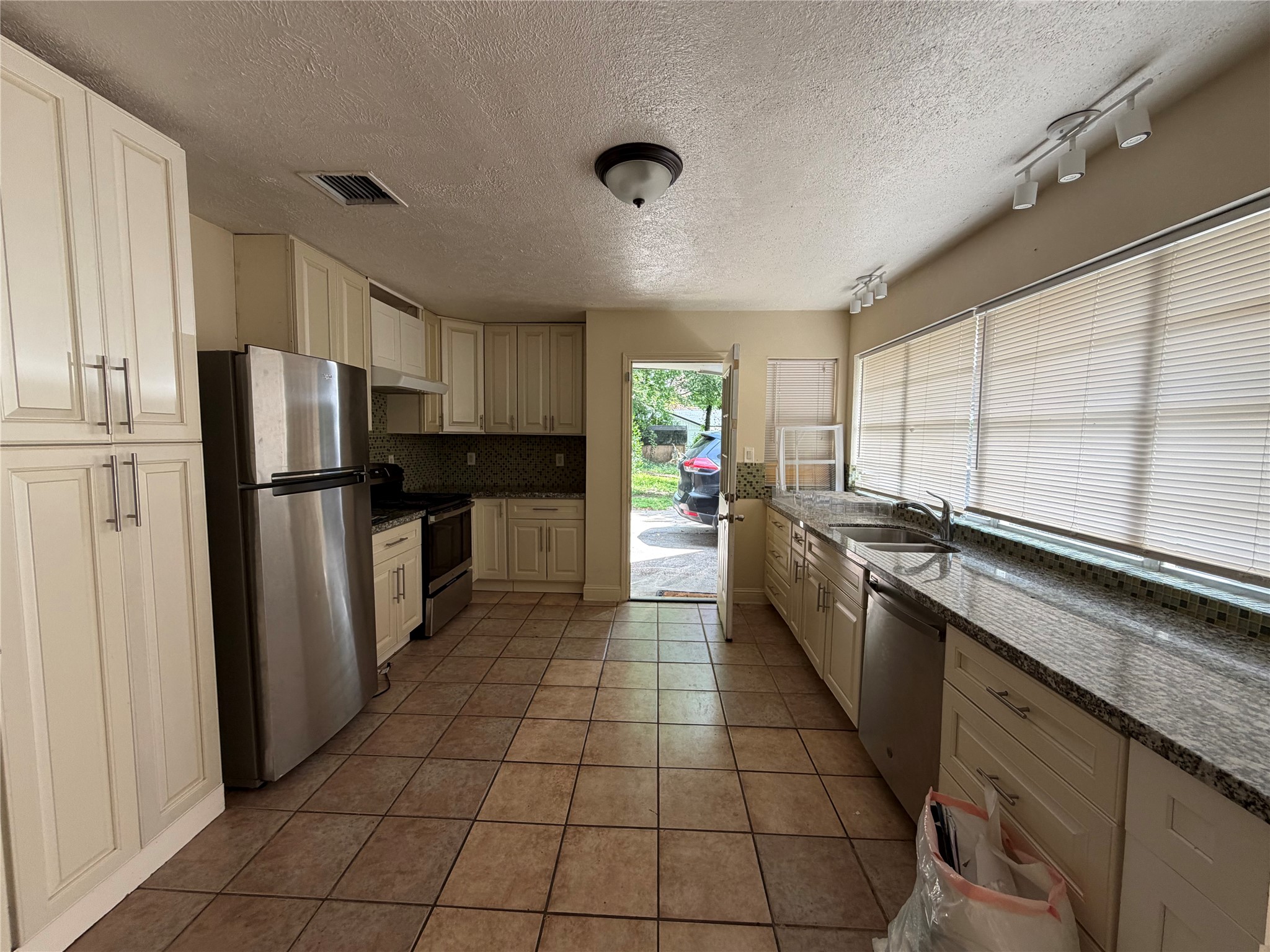535 Brandon Road Conroe, TX 77302 - Photo 5 of 10 a kitchen with stainless steel appliances a refrigerator sink and cabinets