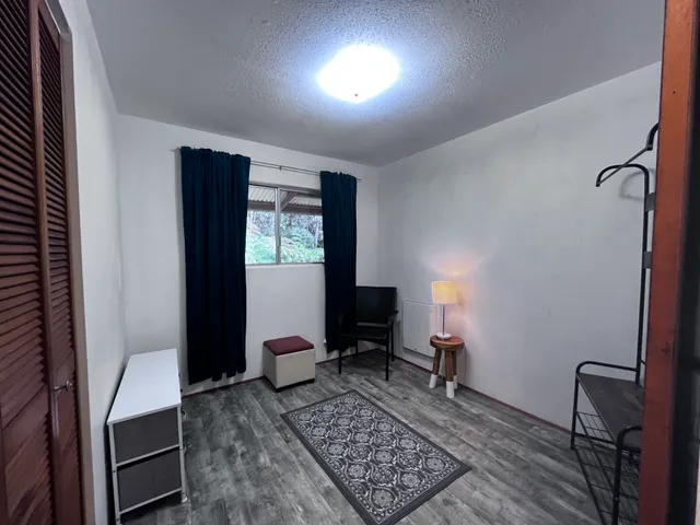 a view of a workspace with furniture and a window