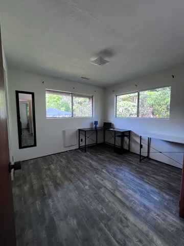 a view of an empty room with window and a living room