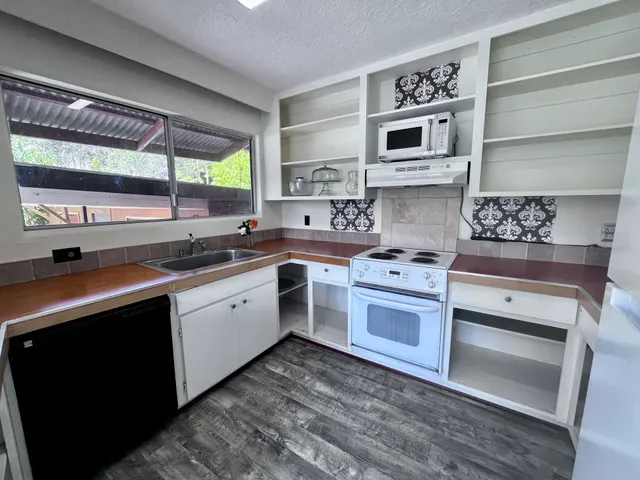 a kitchen with a stove a sink and a microwave